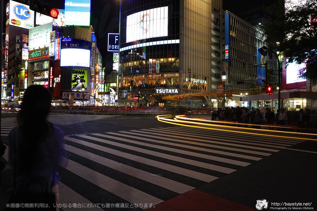 渋谷交差点で信号待ちの女性とレーザービーム